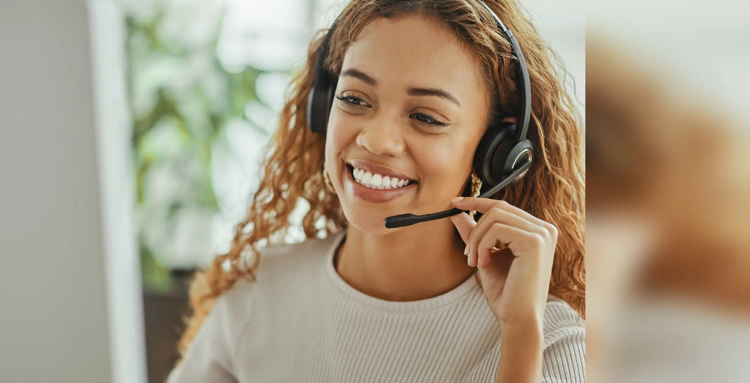 Smiling UK receptionist wearing a headset, taking a call