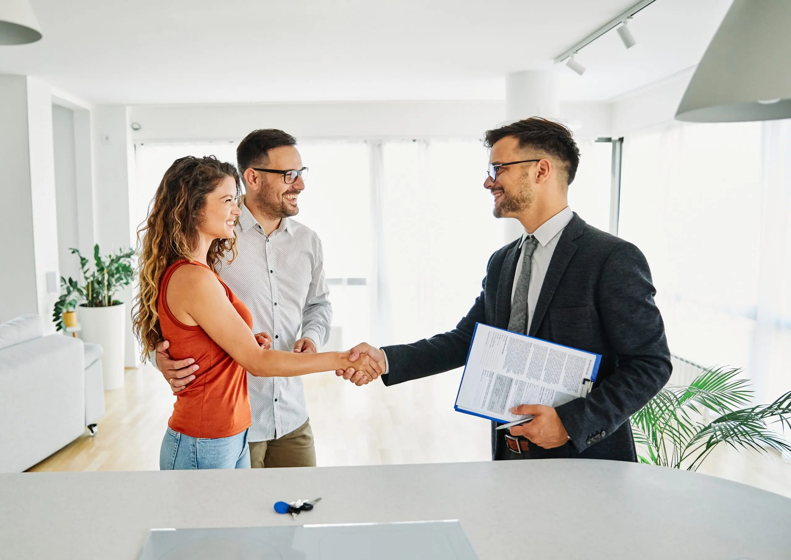Estate agent shaking hands with a couple as they close a sale