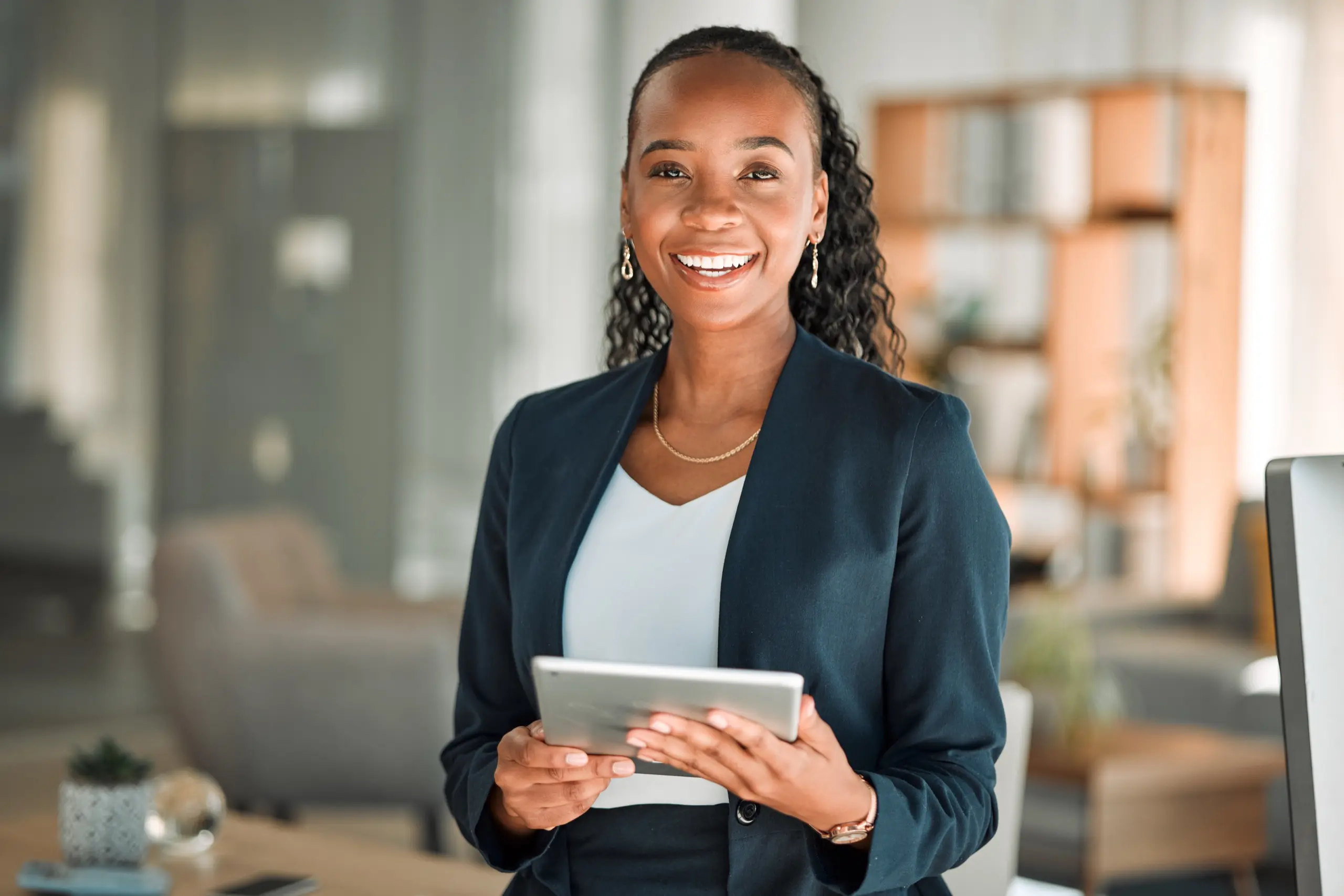 Smiling professional holding a tablet in a modern office
