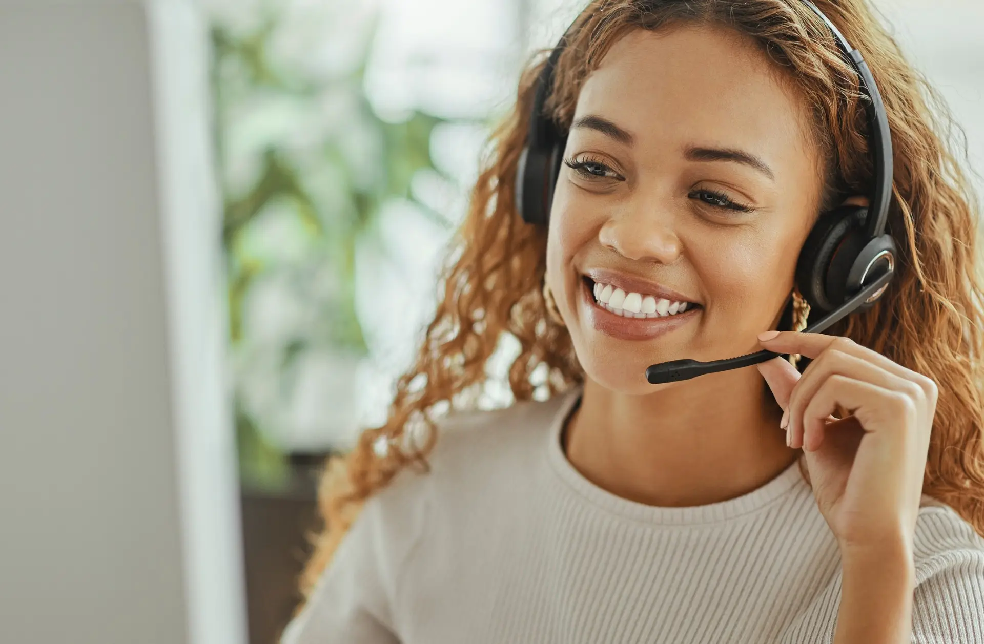 Smiling UK receptionist wearing a headset, taking a call